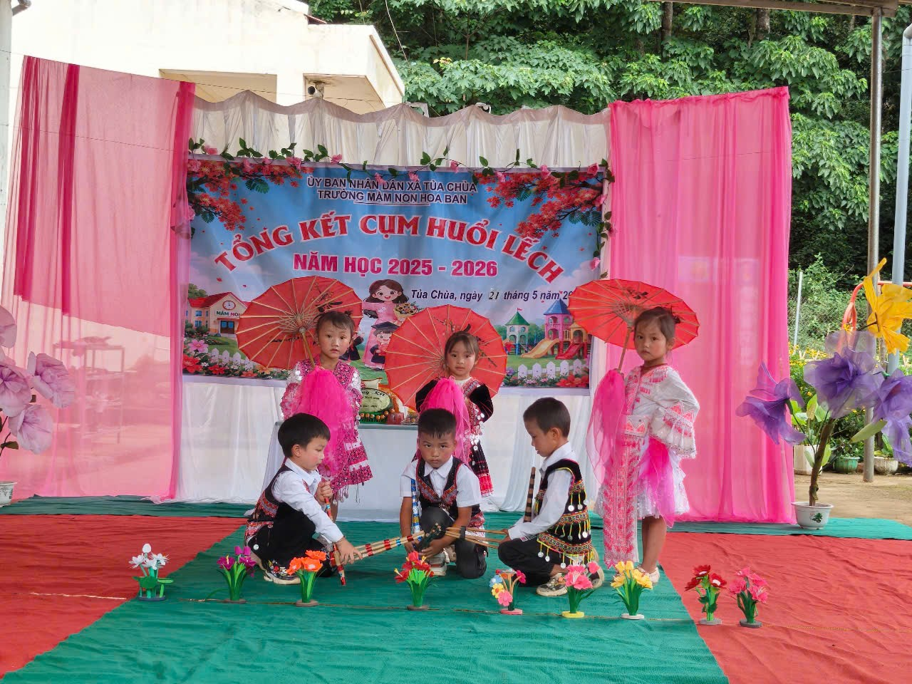 'A group of children performing on a stage

Description automatically generated'
