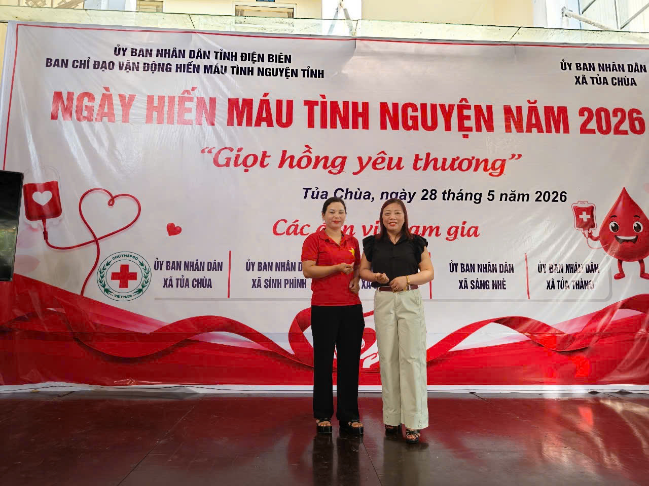 'Two women standing in front of a banner
AI-generated content may be incorrect.'